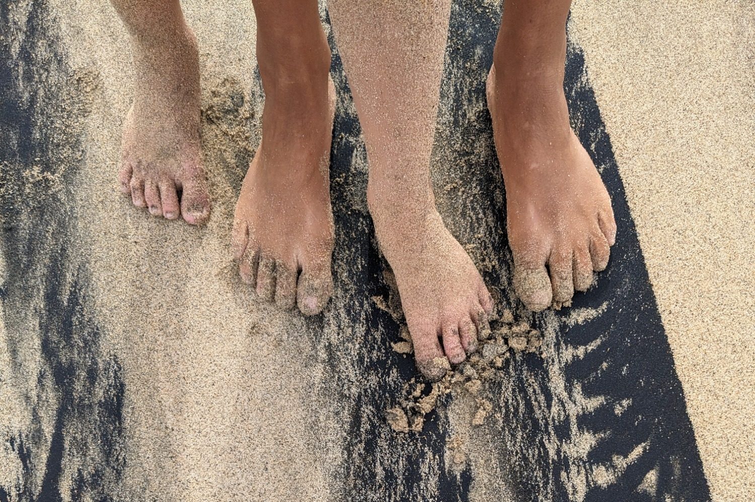 Twee paar voeten in het zand, symbool voor rust en verbinding via lichaamsgerichte psychologie